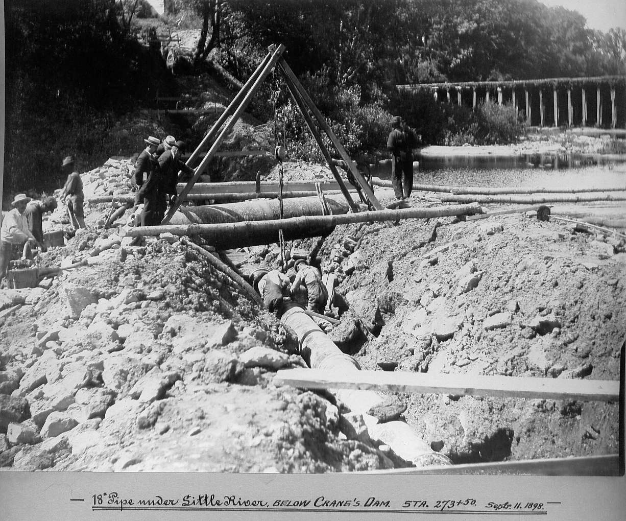 Men laying pipe in trench