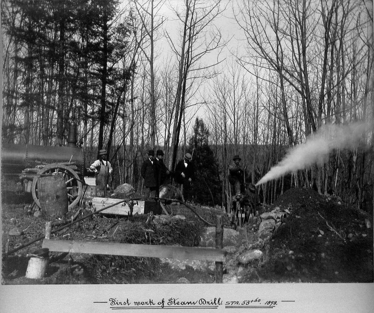 Men operating steam drill